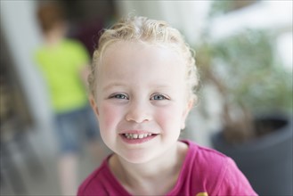 Portrait of blonde girl (4-5) looking at camera and smiling