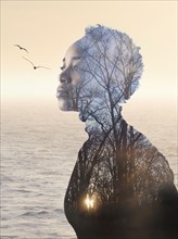 Composite image of woman, forest and seascape.