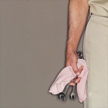 Mechanic holding wrenches and towel.