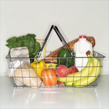 Wire basket full of groceries.