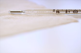 Close-up view of thermometer lying on tissue.