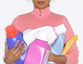 Detergent bottles held by mid adult woman.