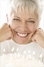 Smiling mature woman with birthday cake.