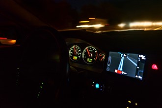 Dashboard of car on highway at night.