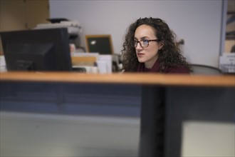 Young woman looking at computer monitor.