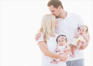 Studio shot of happy family with two baby girls (2-5 months) on white background
