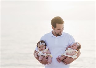 Happy father holding babies (2-5 months)