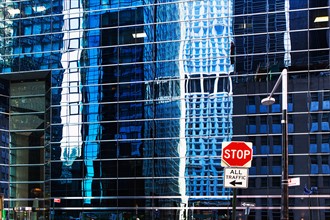 USA, New York, Distorted reflections in office building and stop sign in front