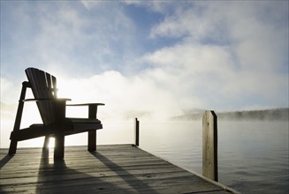 USA, New York, Chair on pier during sunrise