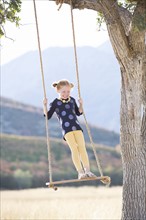 Girl (4-5) standing on swing