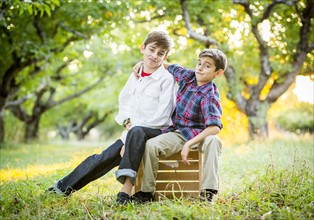 Smiling brothers embracing in cherry orchard