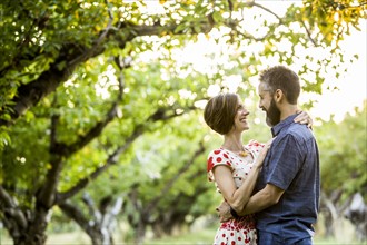 Couple embracing in cherry orchard