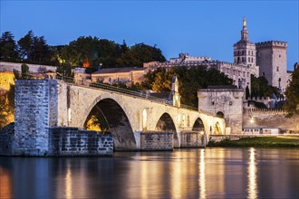 France, Provence-Alpes-Cote d'Azur, Avignon, Pont Saint-Benezet on Rhone River and Avignon Cathedral at dusk