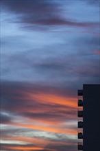 Silhouette of apartment building against colorful sky at sunset