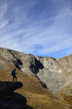 USA, Colorado, Silhouette of hiker on rock ledge along Chicago Lakes Trail in Mount Evans Wilderness Area