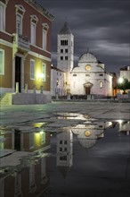 Croatia, Zadar, Buildings reflecting in puddle at dusk