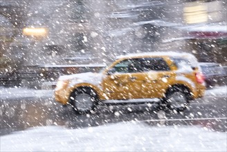 USA, New York State, New York City, Yellow cab driving during snowstorm.