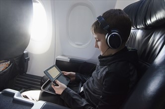 Boy sitting in plane and playing video game