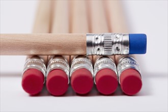 Wooden pencils with red erasers, one with blue on top