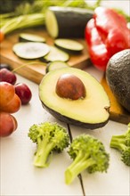 Avocado surrounded by various fruits and vegetables