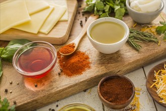 Spices, olive oil, vinegar and cheese on cutting board