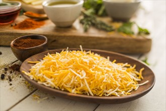 Shredded cheese on wooden plate