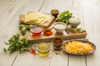 Cheese, oils and herbs on table