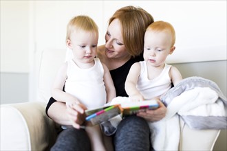 Mother and sons (12-17 months) reading picture book