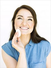 Woman removing make-up with cotton pad