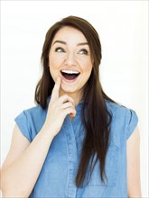 Woman wearing blue top touching face and laughing
