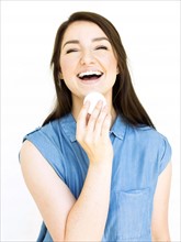 Portrait of woman laughing and holding cotton pad