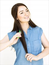 Woman wearing blue top brushing hair