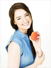 Woman wearing blue top holding peach
