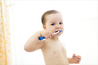 Shirtless boy (4-5)  brushing teeth