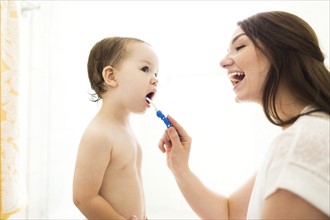 Mother brushing son (4-5) teeth