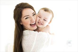 Mother carrying son (4-5) and laughing