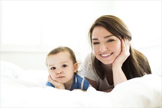 Mother and son (4-5) lying on bed