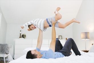 Father and son (4-5) playing in bedroom