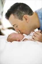 Father kissing daughter (0-1 months)