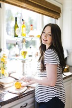 Woman cutting lemon in kitchen