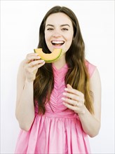 Woman in pink dress eating fruit
