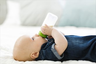 Side view of baby boy ( 12-17 months) drinking milk from bottle