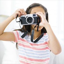 Girl (10-11)  holding camera and taking photo