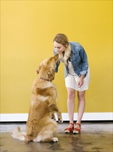 Young woman playing with golden retriever