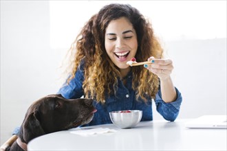 Woman with dog eating snack