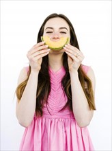 Woman holding slice of melon in front of her mouth