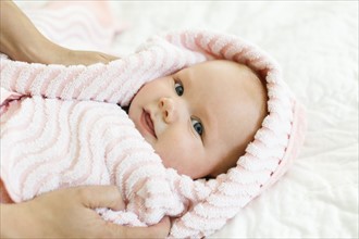 Portrait of baby boy (12-17 months) in pink blanket