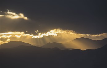 USA, Colorado, Denver, Dramatic sky with sunbeams over mountain range