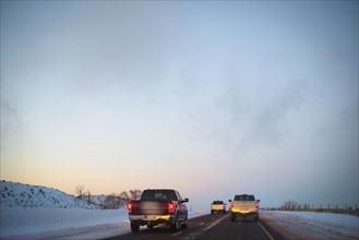 USA, New Mexico, Pick-ups on interstate road in winter at dusk