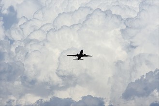 Airplane in sky with clouds in background